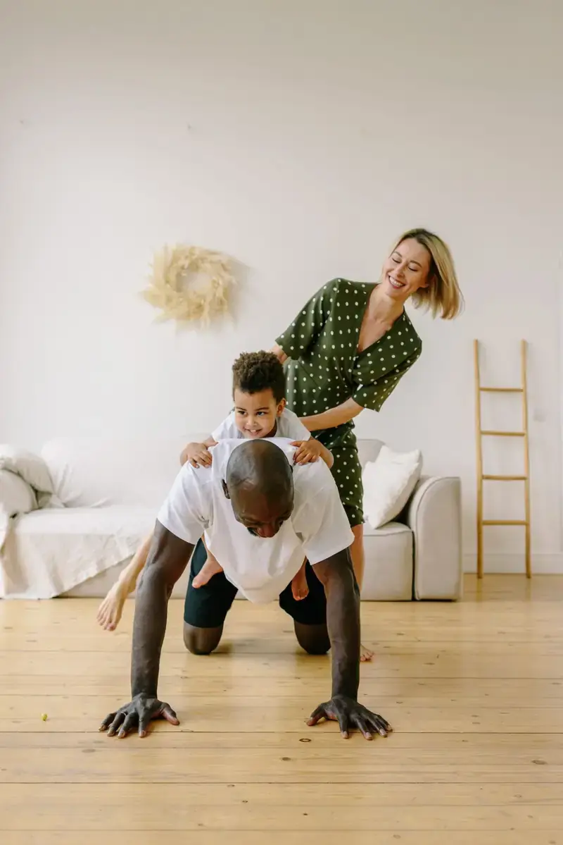 Padre haciendo flexiones mientras su familia entrena a su lado